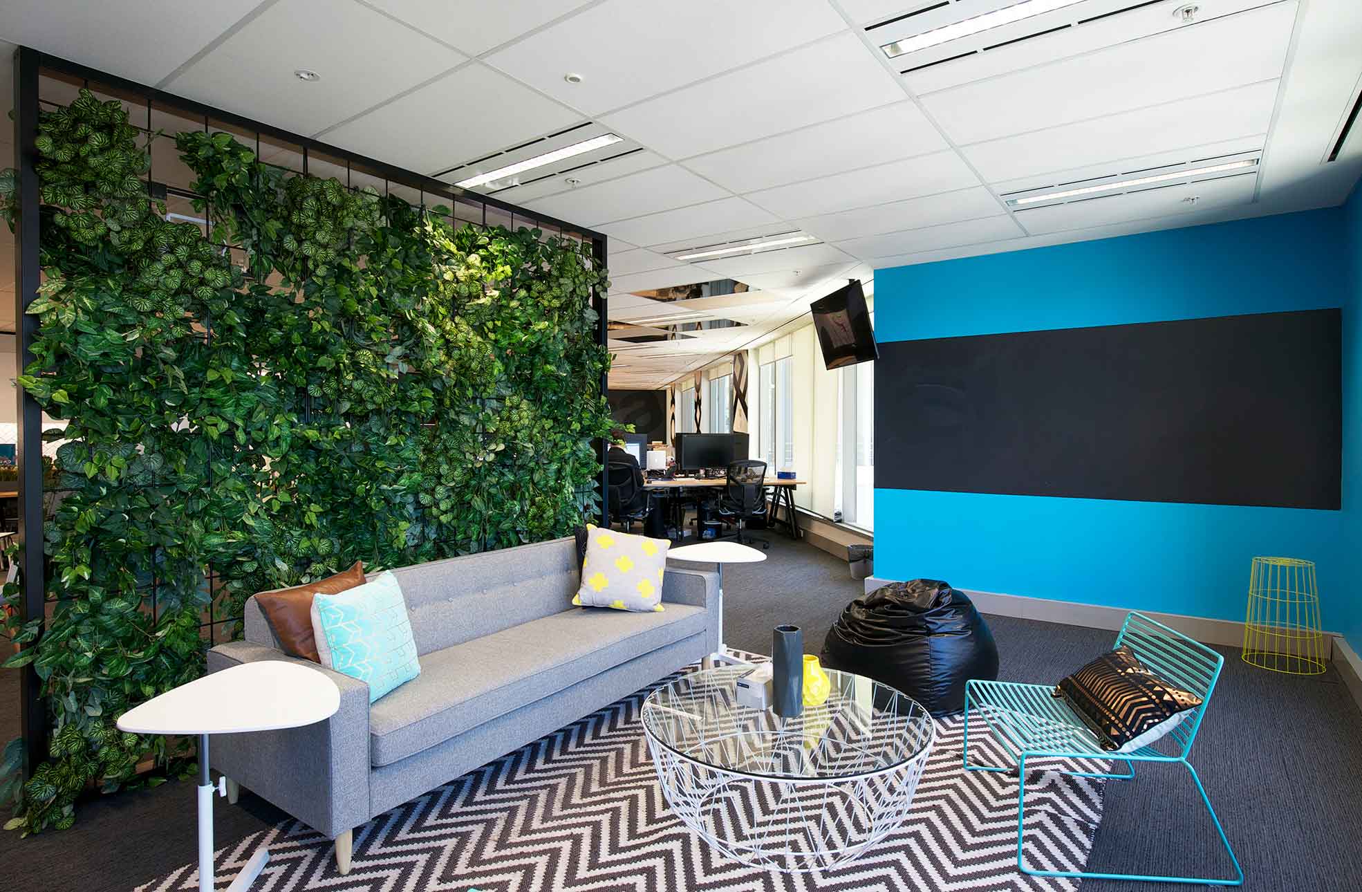 Office fitout solution breakout area with wall garden, coffee table, lounge, wire frame chairs, bean bag 